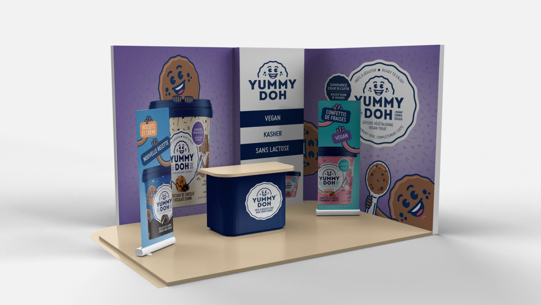 Le stand d'exposition de Yummy Doh, aux couleurs violet et blanc, présente des bannières, des emballages de produits et un comptoir. Des textes mettent en avant la pâte à cookies végane et sans lactose. Une mascotte illustrée en forme de cookie orne le stand.