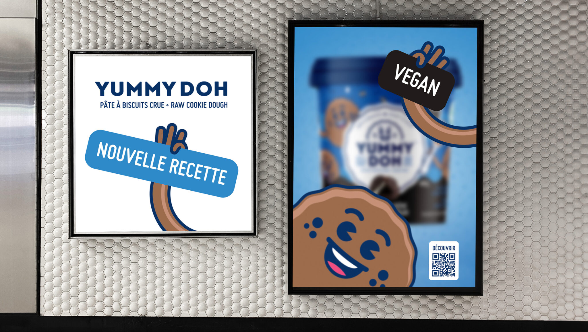 Deux affiches accrochées à un mur carrelé font la promotion de la pâte à cookies crue « Yummy Doh ». L'une porte la mention « Nouvelle Recette », tandis que l'autre représente un cookie de dessin animé tenant une pancarte « Vegan », accompagnée d'un pot du produit et d'un code QR.