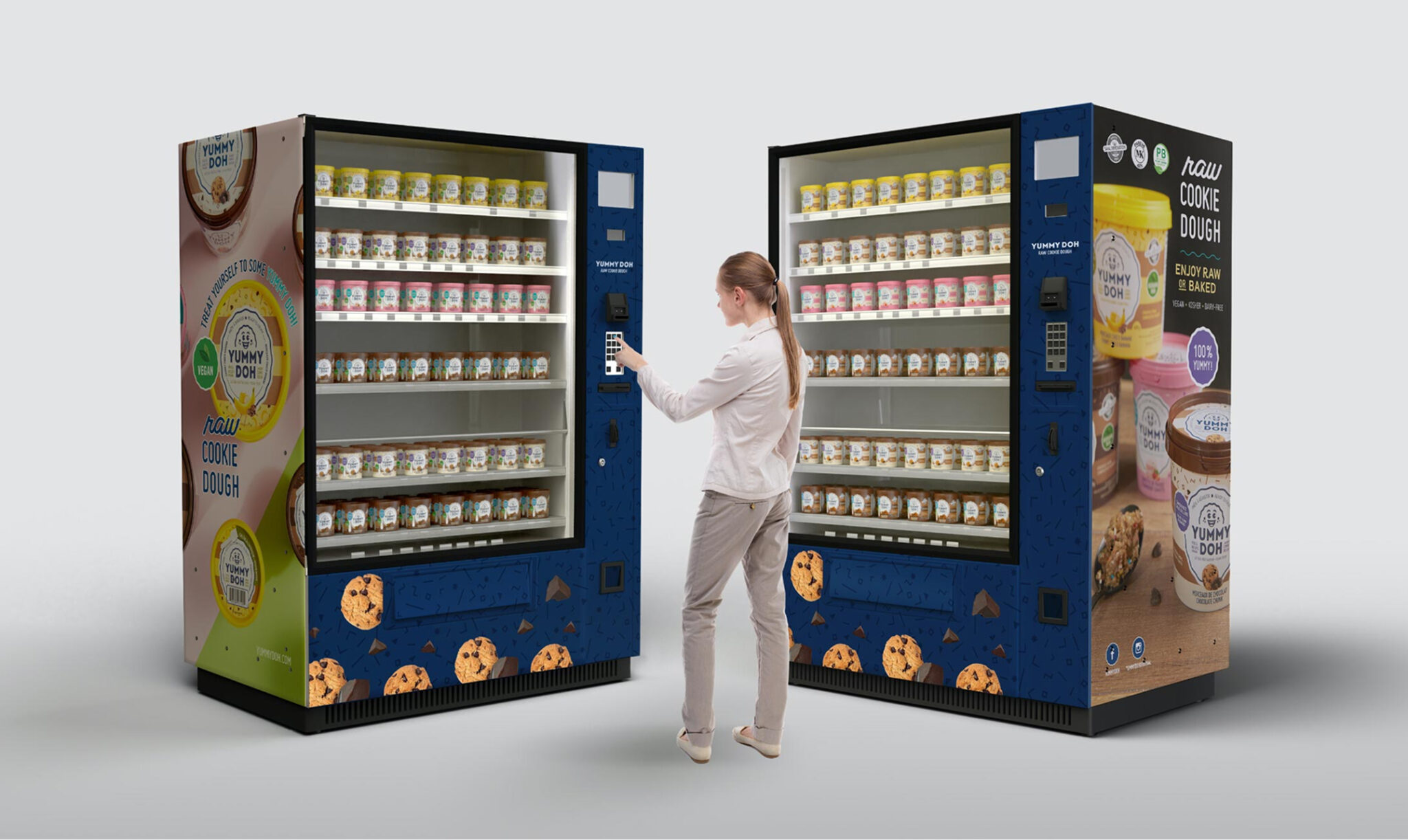 Une femme se tient devant deux distributeurs automatiques remplis de barquettes de pâte à cookies et sélectionne une option sur l'écran tactile. Les distributeurs sont décorés d'images de cookies et d'étiquettes de produits colorées.