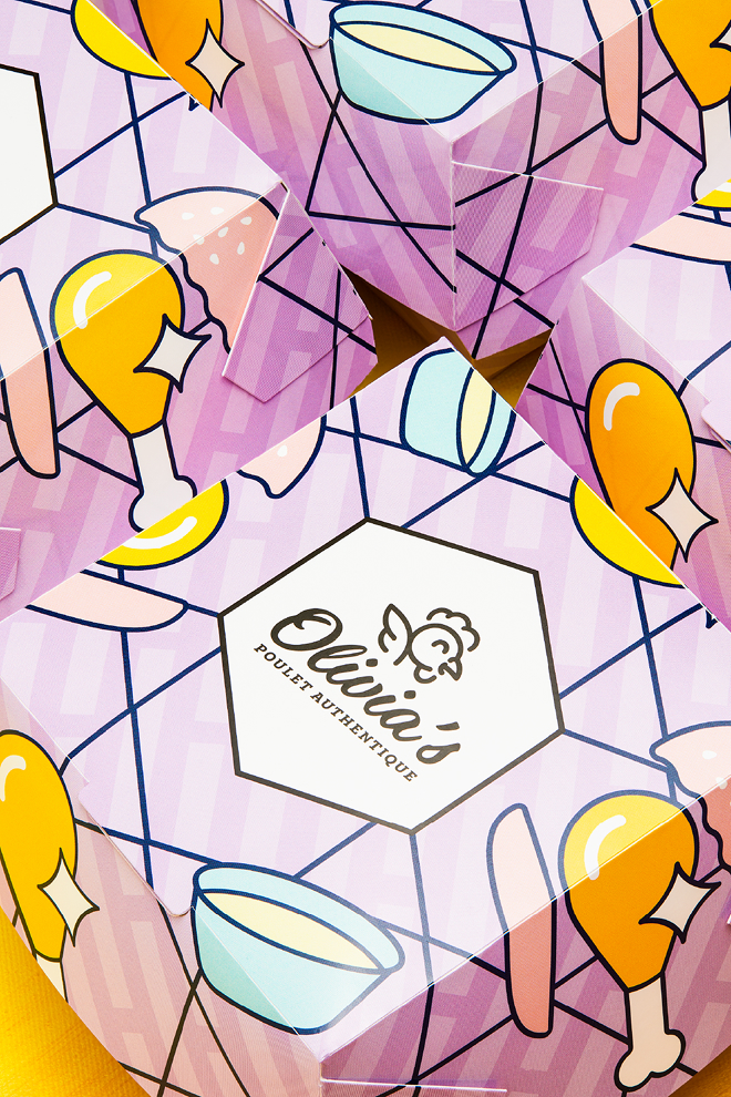 Un emballage coloré orné d’illustrations représentant des pilons de poulet frits, des bols et des boissons. Sur la boîte centrale figurent le logo d’Olivia’s Chicken et la mention « Olivia’s Poulet Authentique », sur un fond violet clair à motifs, pour une expérience poulet authentique.