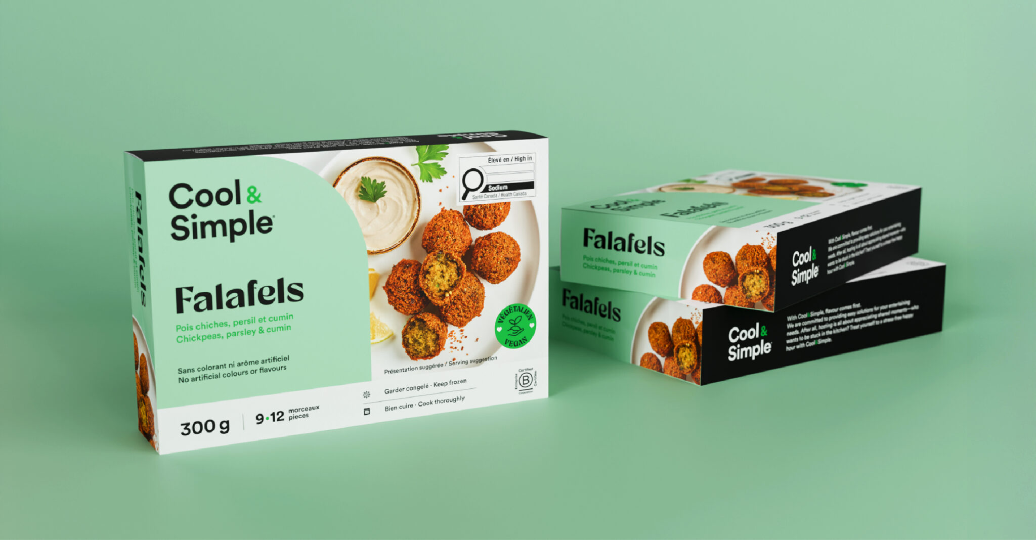 Deux boîtes vertes de falafels « Cool & Simple » sont présentées sur un fond vert. L'emballage comporte des images de falafels accompagnés d'une sauce, les informations sur le produit et des icônes nutritionnelles. Une boîte est posée à l'horizontale, tandis que les deux autres sont empilées.