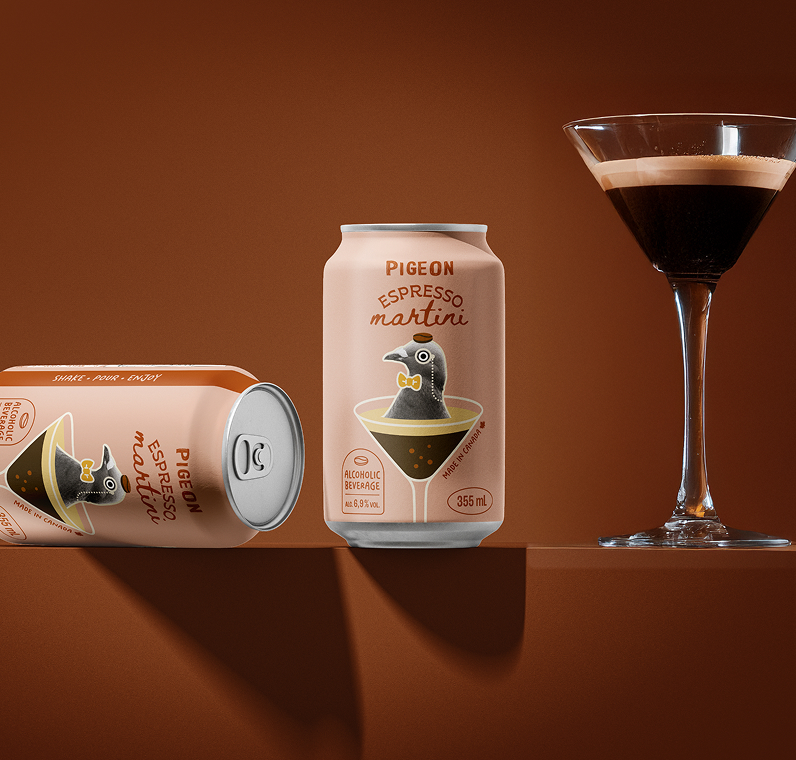 Deux canettes de « Pigeon Espresso Martini », issues d'un partenariat créatif, arborent sur leur étiquette un pigeon de bande dessinée dans un verre à martini et sont présentées à côté d'un verre rempli d'espresso martini, sur un fond marron.
