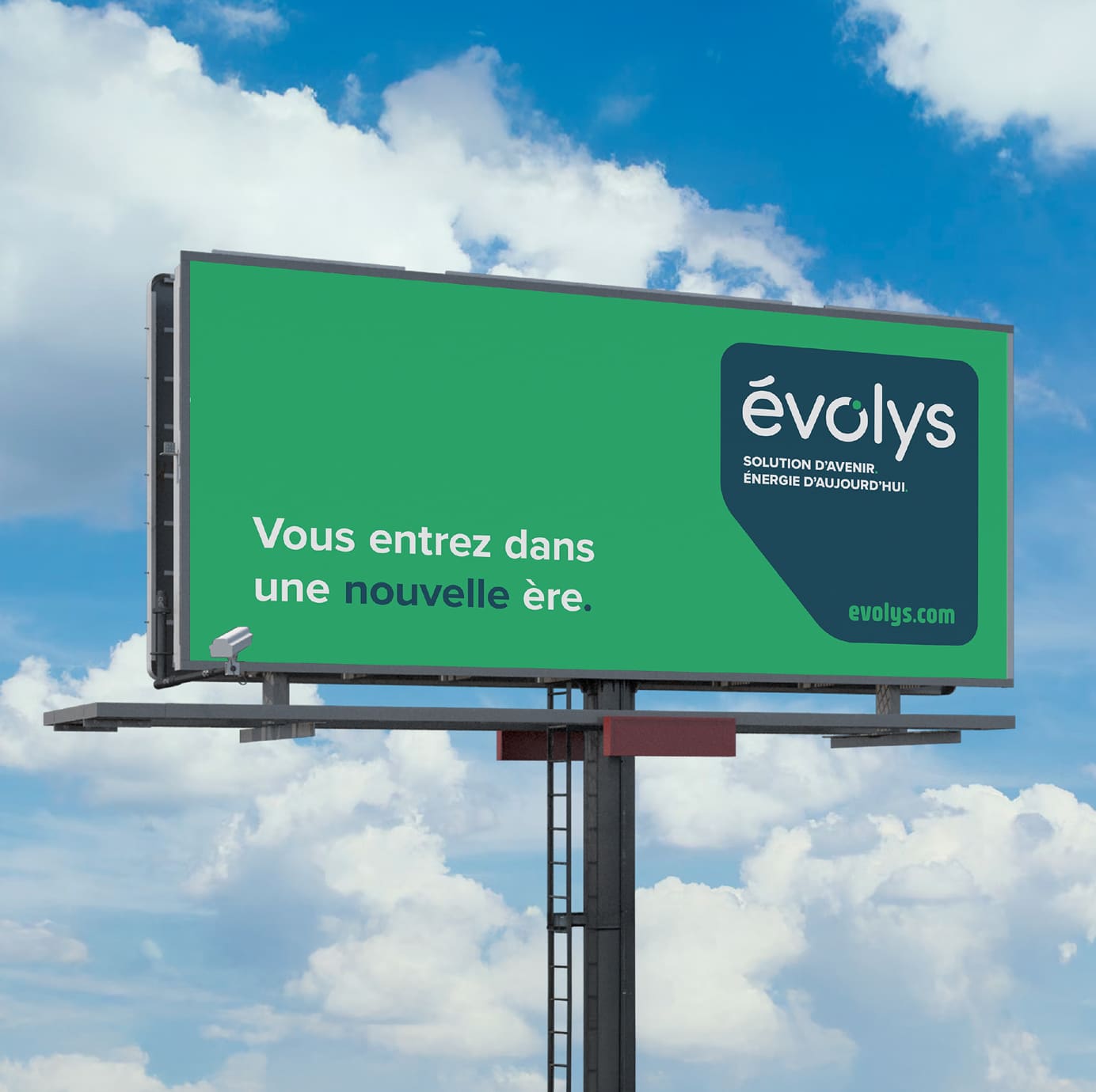 Un grand panneau publicitaire vert arborant le logo « évolys » et le texte « Vous entrez dans une nouvelle ère. » en lettres blanches et vertes, sur fond de ciel bleu. L'adresse du site web evolys.com apparaît en bas à droite.