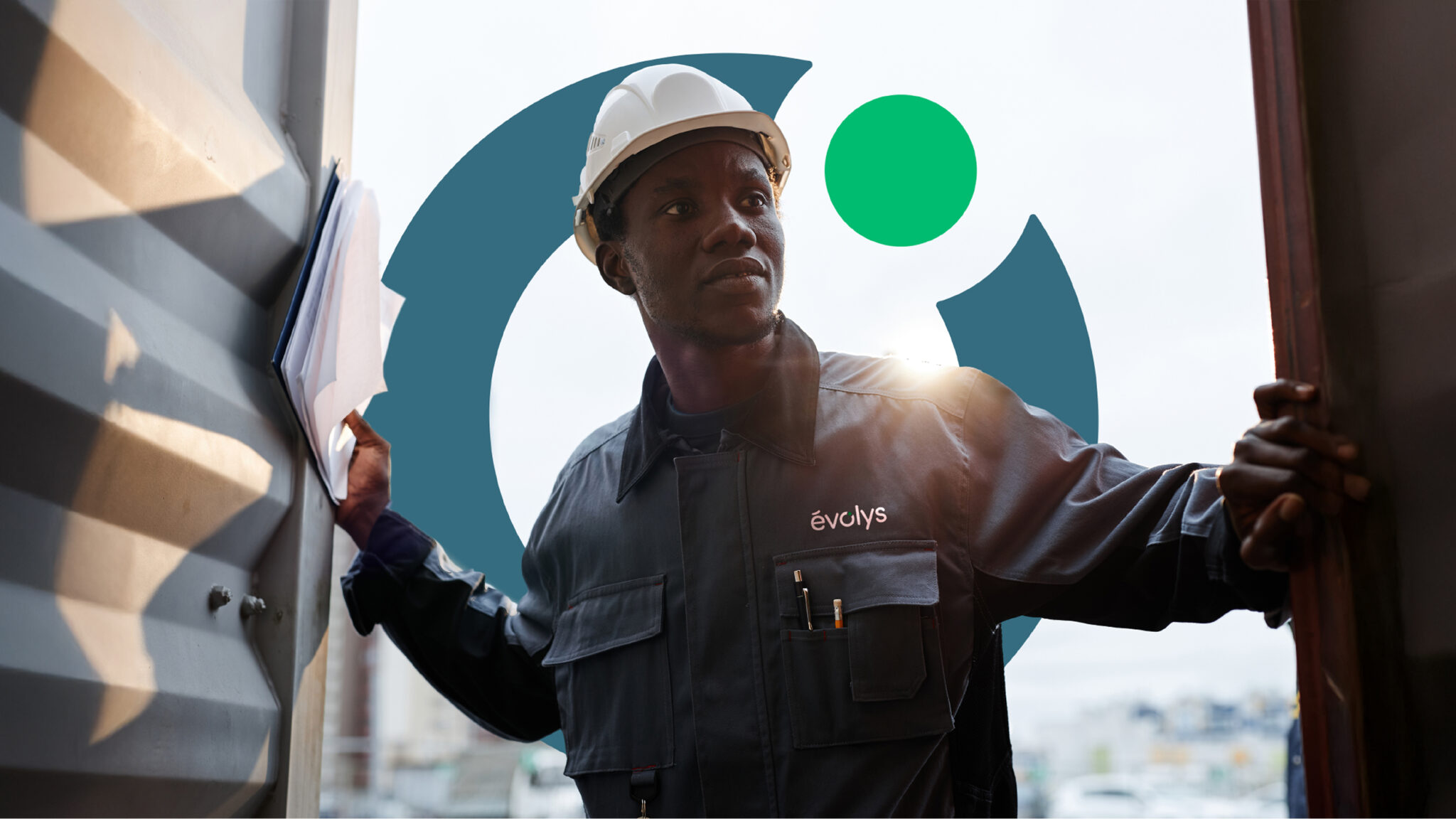 Un ouvrier vêtu d'un uniforme sombre et d'un casque blanc se tient dans l'embrasure d'une porte, des documents à la main. Sur sa veste figure un logo « evolys » blanc, avec un motif circulaire bleu sarcelle en arrière-plan.