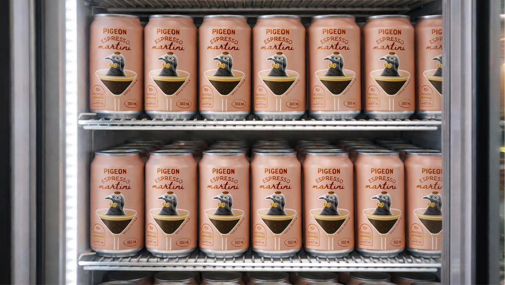 Des canettes de « Pigeon Espresso Martini », ornées de logos illustrés représentant des pigeons, sont soigneusement disposées sur les étagères d'une vitrine réfrigérée.